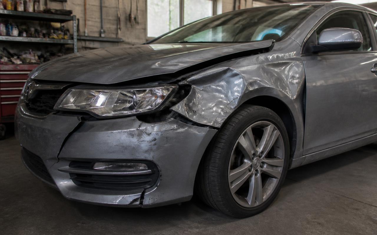 Car with collision damage before repair at New Era Customs